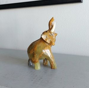 Elephant figurine with striped onyx tusk in brown, green, beige and white.